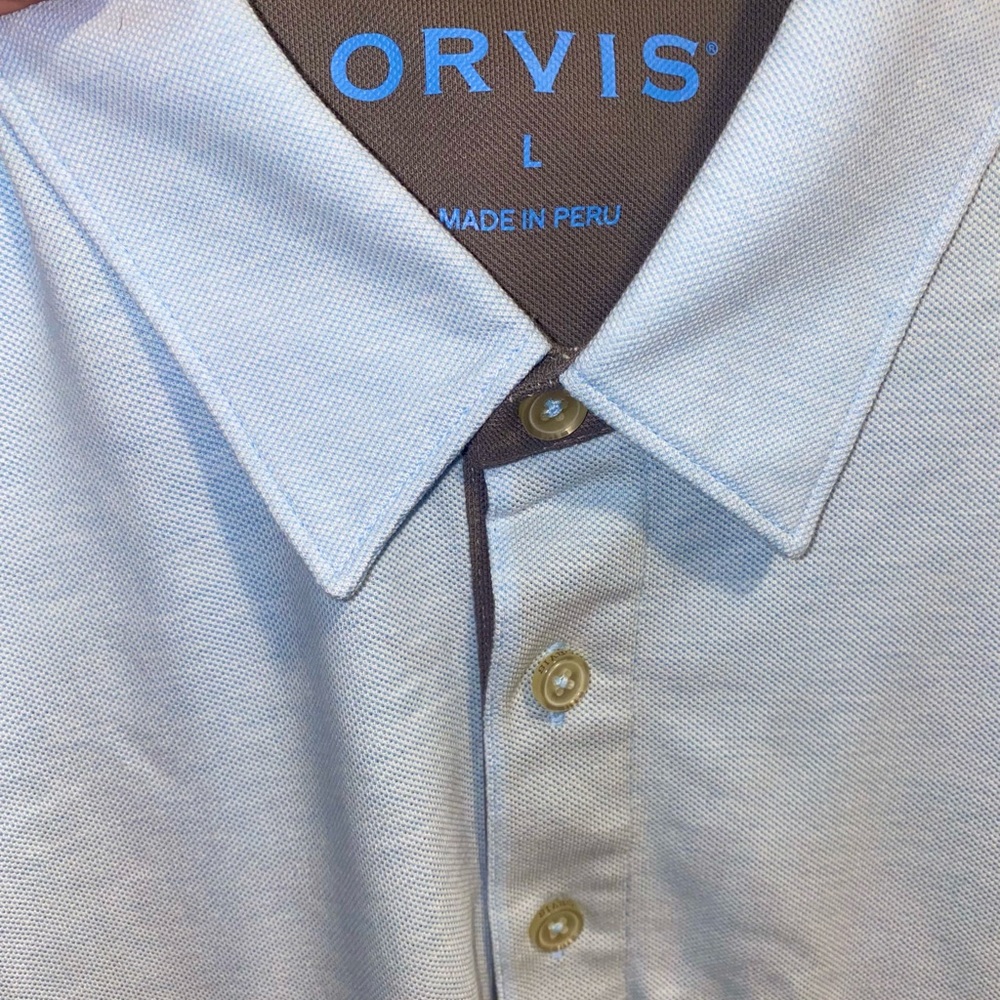 Brand new with tags Orvis light blue polo shirt.
